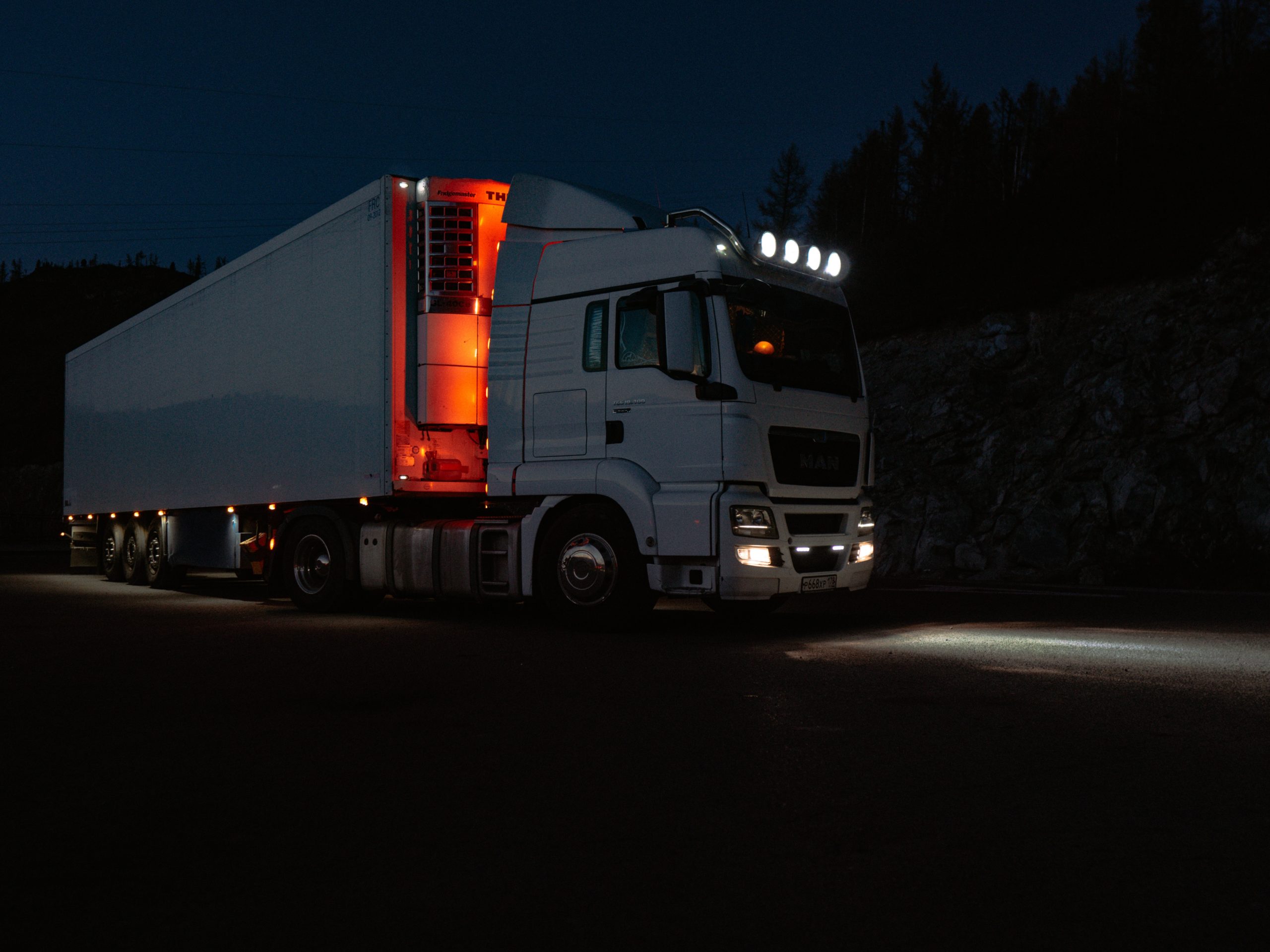 Tractor-trailer driving down the road at night