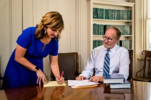 Robert S. Marcus at his desk having a consultation with a team member