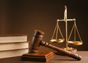 Gavel, books, and scales of justice on a brown background