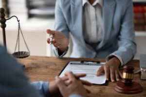 Female American lawyer consulting with clients on legal, financial, and contract matters at a desk.