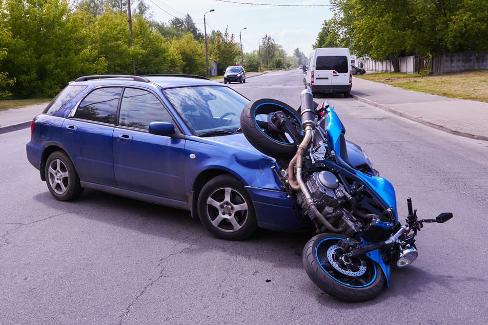 Damaged car and motorbike on a city road at the scene of an accident