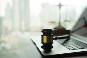 judge gavel and computer on desk of lawyer with legal icon.