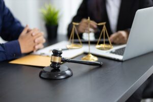 Dog bite lawyer discusses legal options with a client over contract papers on a wooden desk in the office.