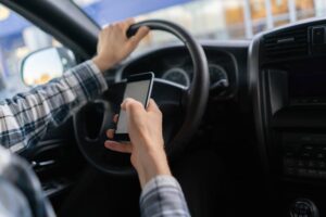 A man is using smartphone while driving car