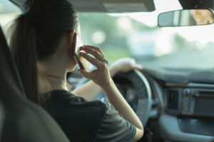 A distracted woman talking on her phone caused a driving accident.