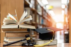 Concept of legal education with a judge's gavel, textbooks, and a mortarboard in a library, symbolizing law studies, judicial knowledge, and litigation.