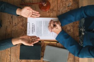 A contract of sale sits on a table in a lawyer's office, drafted by the firm for the client to sign, as part of their legal advisory services.