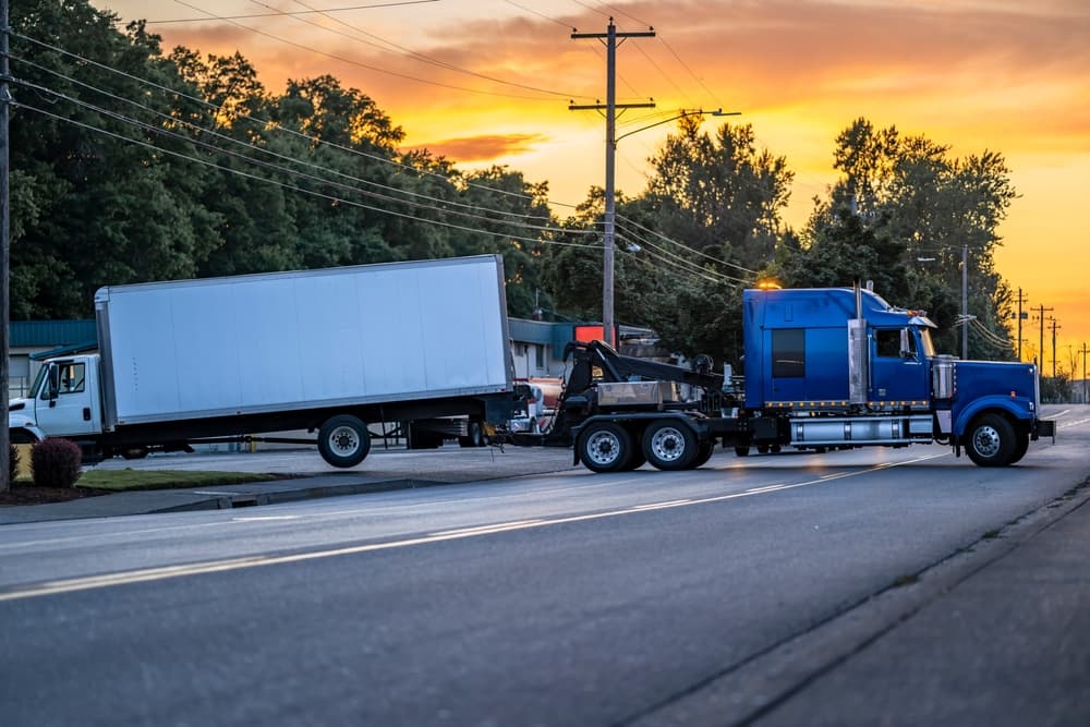 Mobile blue roadside assistance powerful tow big rig semi truck tractor towing broken after accident day