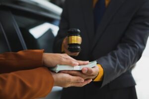 Two person holding money in the their hands along with gavel 