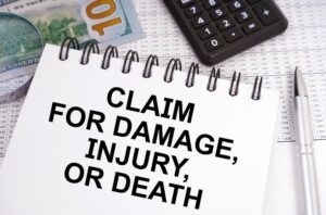 Claim for Damage, Injury of Death written on a notepad