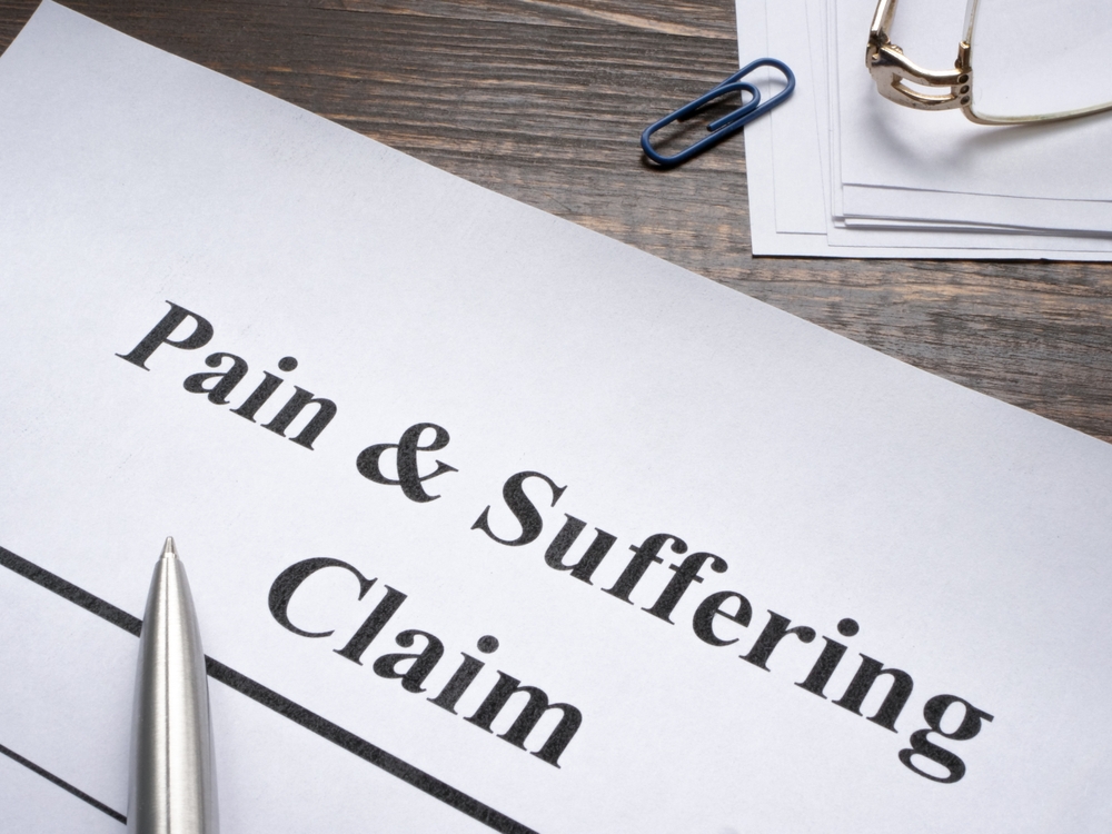 Pain and suffering claim form with pen on desk
