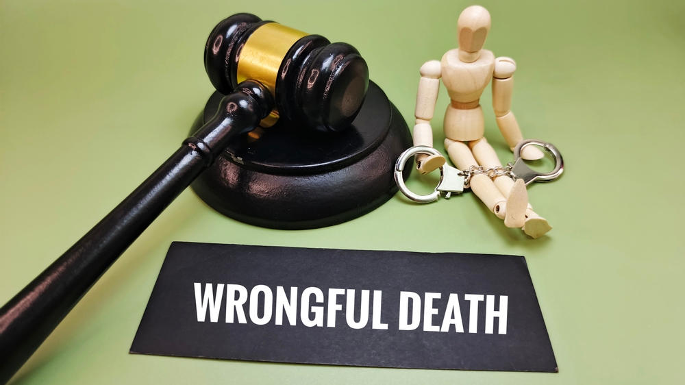 Gavel, handcuffs, and ‘Wrongful Death’ sign symbolizing legal support an attorney provides after the loss of a loved one.